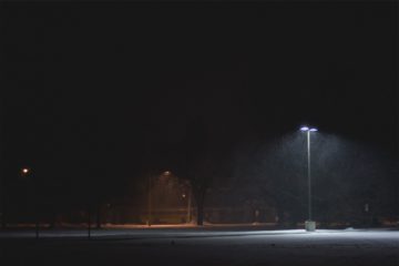 parking vide, de nuit, éclairé par un lampadaire